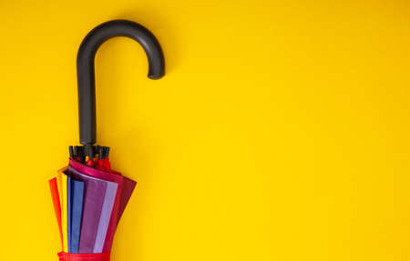 Fragment of umbrella hook on yellow background. Top view. Autumn accessories. Copy spaceの写真素材