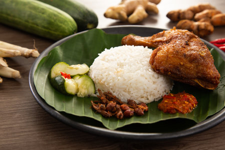 Nasi Kukus is usually comprising freshly steamed rice, crispy fried chicken, sambal belacan, acar and a curry gravyの写真素材