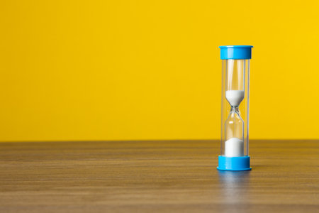 Time sand on yellow background. Time Conceptの写真素材