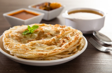 Roti Parata or Roti canai with lamb curry sauce - popular Malaysian breakfastの写真素材