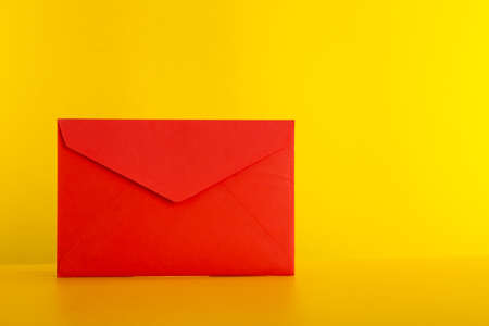 Colorful paper envelopes on yellow background - top viewの写真素材