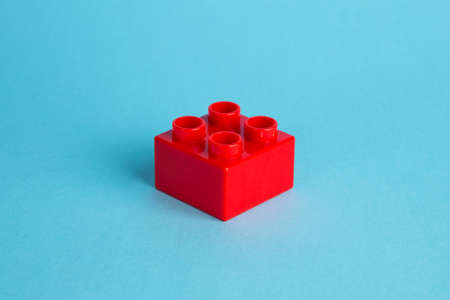 Plastic building blocks on red background