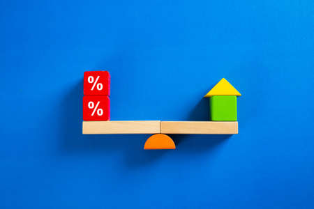 Interest rate up and Banking concept, Model house with Percentage symbol icon on wood scale seesaw.の写真素材