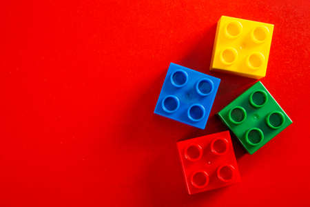 Plastic building blocks on red background