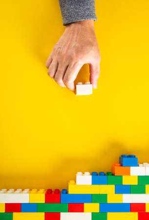 hand stacking up the colorful plastic block