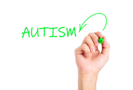 Doctor hand writing AUTISM word on a transparent wipe board.の写真素材
