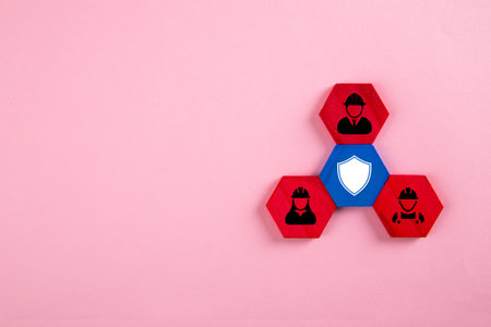 Workers and shield on wooden blocks. Medical insurance, labor safety and health protectionの写真素材