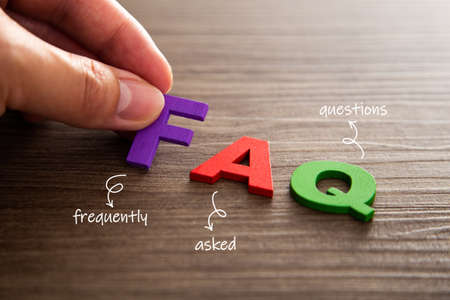 Hand puts a letter F from the word FAQ. Communication and business conceptsの写真素材