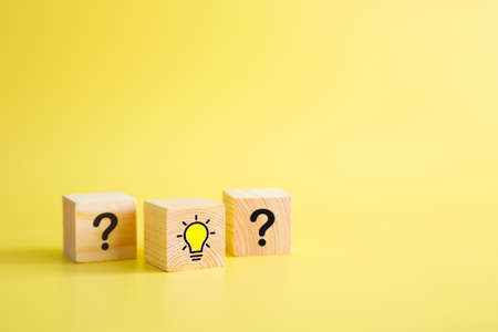 Lightbulb icon and question mark print screen on wooden block cube. It is creative thinking idea and innovation concept.の写真素材