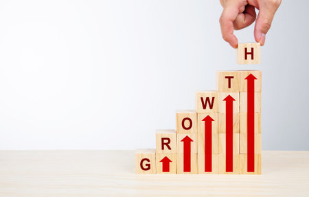 Ladder career path for business growth success process concept.Hand arranging wood block stacking as step stair with arrow up and word GROWTHの写真素材