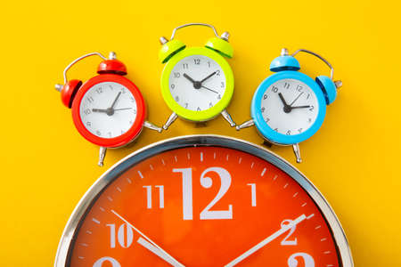 Alarm clock on isolated yellow background.
