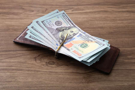 US Dollar bills stack on wooden table