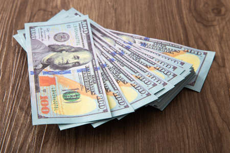 US Dollar bills stack on wooden table