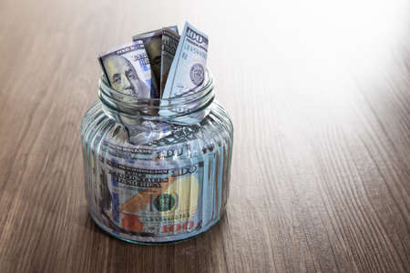 Glass jar with many of dollars money, Saving Conceptの写真素材