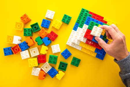 hand stacking up the colorful plastic blockの写真素材