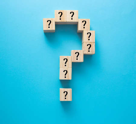 Question marks on wooden blocks, financial business concept, blue background