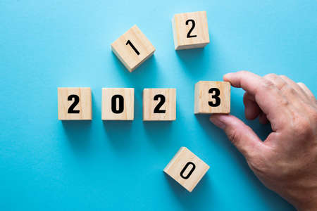 Hand making a 2023 on blue background for preparation new year change.の写真素材