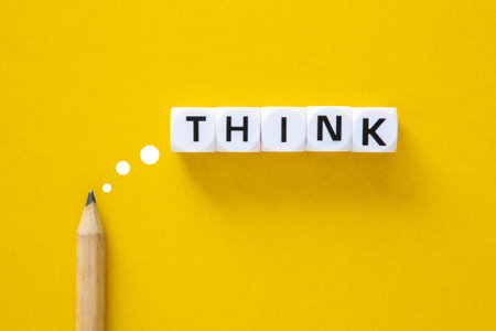 Pencil with the word think on yellow background. Thinking for creative ideas concept.の写真素材