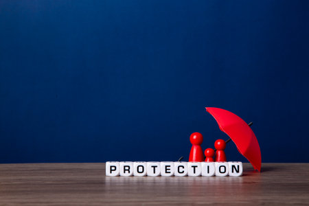 Umbrella and wooden doll figures. Insurance coverage concept.の写真素材