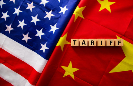 Us and china flags with wooden cubes spelling tariff, representing trade war and tariffs between...