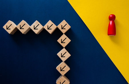Concept of different business leadership with red manager changing direction from wooden blocks with arrowsの写真素材