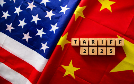 Wooden cubes spelling tariff and 2025 placed on overlapping american and chinese flags, representing trade war and tariffsの写真素材