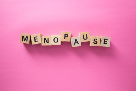 Menopause concept with wooden cubes forming the word on a pink backgroundの写真素材