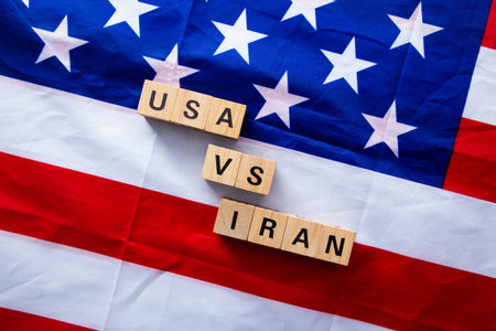 Usa and iran confronting each other with wooden blocks on a us flag symbolizing international...