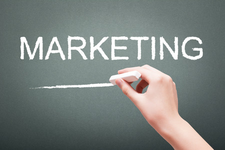 Hand writing with chalk marketing on blackboardの写真素材