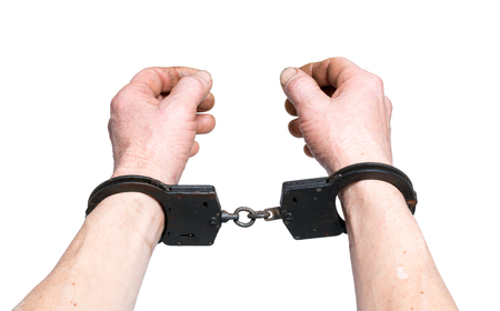Dirty old hands in handcuffs on whiteの写真素材