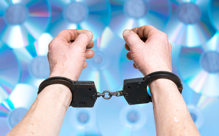 Hands in handcuffs internet piracy conceptの写真素材