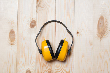 Yellow working protective headphones on wooden table top viewの写真素材