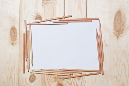 Album pages with pencils for drawing on a wooden tableの写真素材