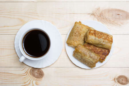 Close up white coffee cup and pancakes with cottage cheese on wooden table top viewの写真素材