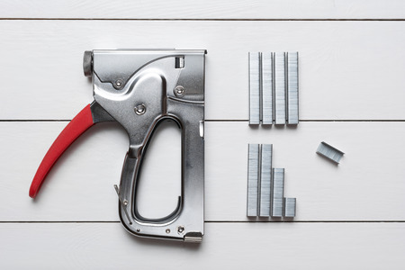 Large tacker stapler gun with clips on white wooden floorの写真素材