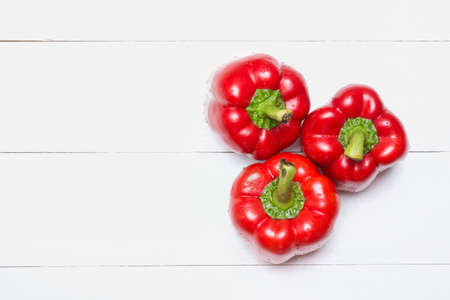 Red bell peppers on white wooden table. Top view with copy spaceの写真素材