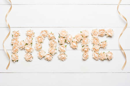 Word home made of white roses with ribbons on white wooden backgroundの写真素材