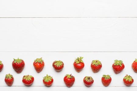 Strawberry pattern on white wooden table with empty copyspaceの写真素材