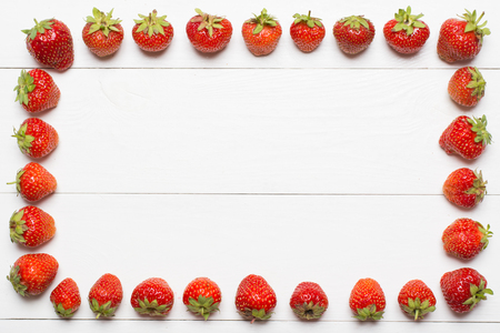 Strawberry frame on white wooden table with empty copyspaceの写真素材
