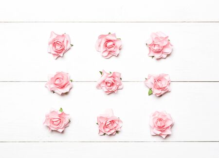 Pink roses grid on white wooden table backgroundの写真素材