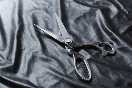Tailor scissors on black leather backgroundの写真素材