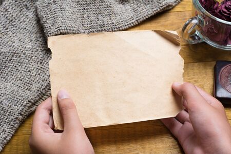 Young hands holding vintage empty paper sheet with copyspaceの写真素材