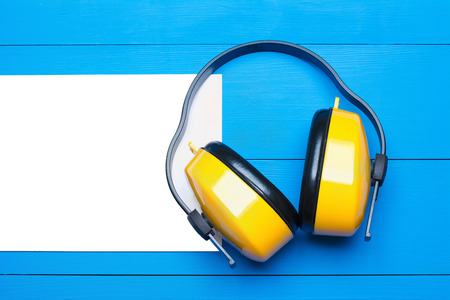 Yellow working protective headphones on blue wooden table backgroundの写真素材