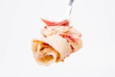 Pappardelle with cream, sun-dried tomatoes and smoked fish on a forkの写真素材