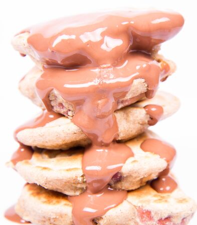 Pancakes with apples being covered with chocolateの写真素材
