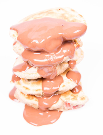 Pancakes with apples being covered with chocolateの写真素材