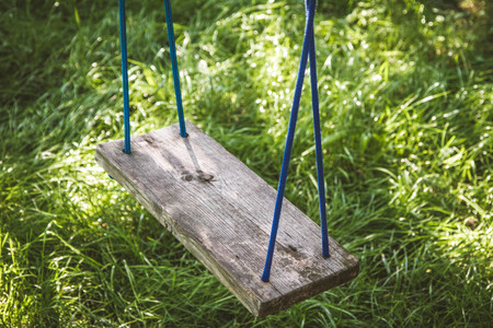 Old wooden swing in a gardenの写真素材