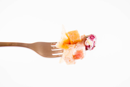 Pasta salad with cheese, ham, kidney beans and mayonnaise on a forkの写真素材