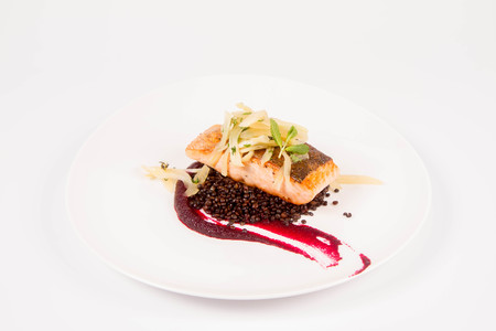 Baked salmon, beetroot mousse, black lentils and pear on a white backgroundの写真素材