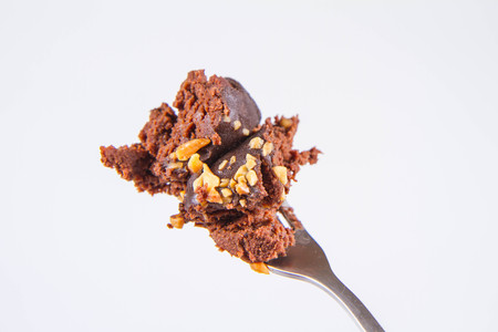 Rum ball decorated with chocolate and nuts on a white background
